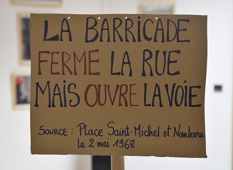 Pancarte de manifestation avec le slogan "La barricade ferme la rue mais ouvre la voie"