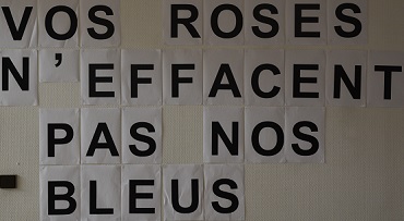 Photo d'un collage féministe avec le message "Vos roses n'effacent pas nos bleus"
